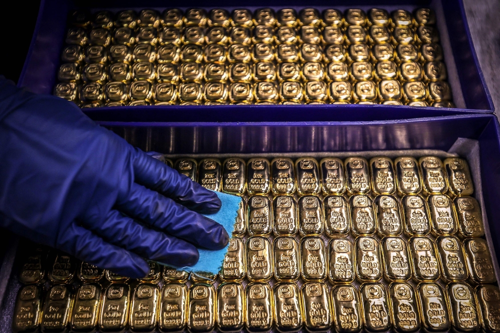 (Files) A worker polishes gold bullion bars at the ABC Refinery in Sydney on August 5, 2020. (Photo by David Gray / AFP)