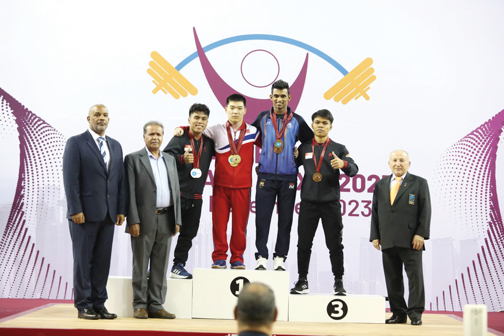 The podium winners of the men's 55kg weight class pose for a photograph with officials on the opening day of the Qatar Cup IWF Grand Prix II 2023 Weightlifting Championships, yesterday.