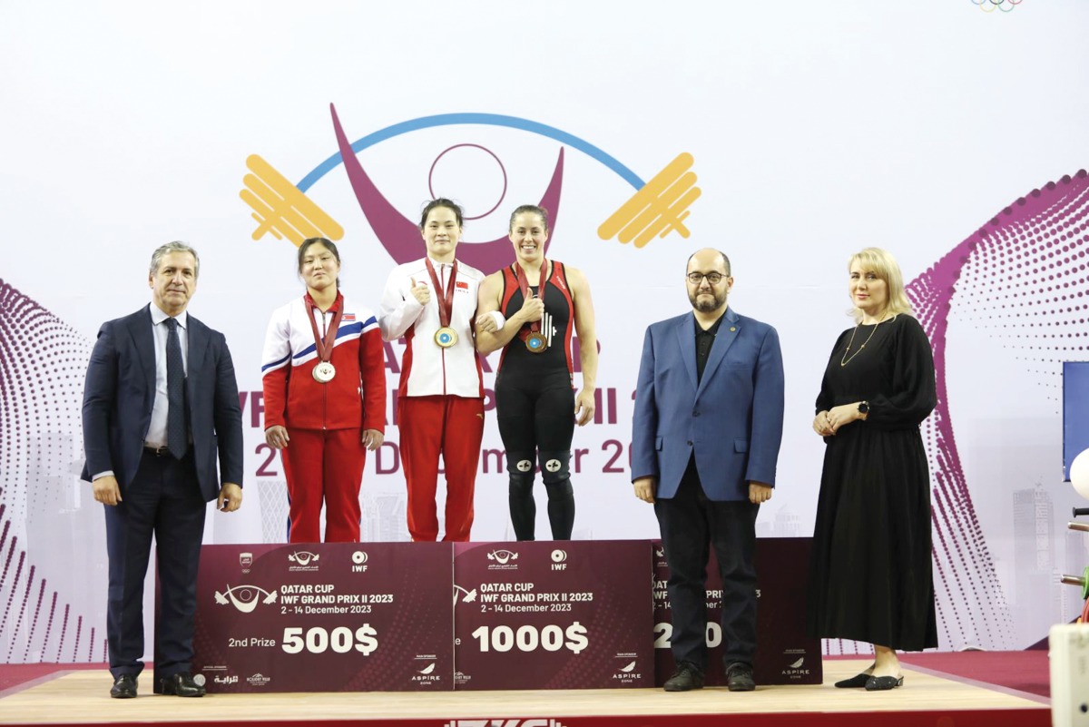 The podium winners of the women's 59kg event at the Qatar Cup IWF Grand Prix II, pose for a photograph with officials, yesterday.