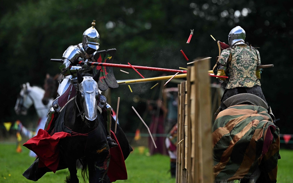 (Files) Chris Sailing as 'The Wyvern' (L) and Ben Green as 'The Wildman' compete on their horses during the Legendary Joust jousting event at English Heritage's Kenilworth Castle, near Coventry, central England on July 29, 2023. (Photo by Oli Scarff / AFP) 