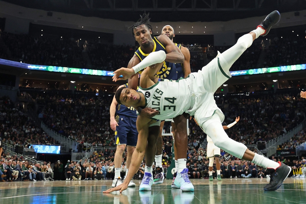 Giannis Antetokounmpo #34 of the Milwaukee Bucks is fouled by Aaron Nesmith #23 of the Indiana Pacers at Fiserv Forum on December 13, 2023 in Milwaukee, Wisconsin. Stacy Revere/Getty Images/AFP 