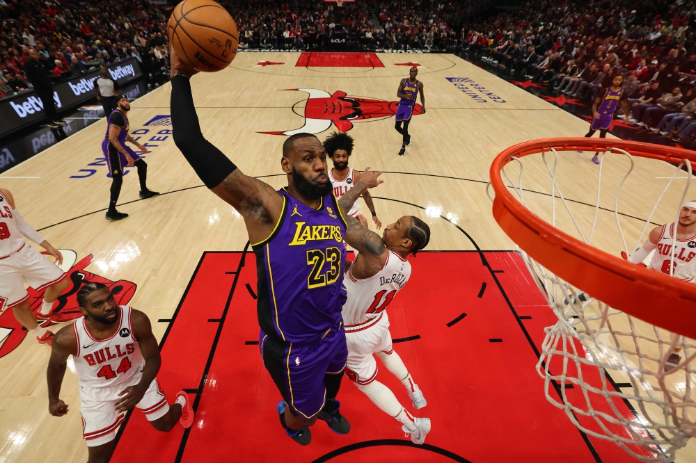 Lebron James 23 of the Los Angeles Lakers dunks over DeMar DeRozan of the Chicago Bulls during the first half at the United Center on December 20, 2023 in Chicago, Illinois. (Photo by Michael Reaves/Getty Images/AFP)