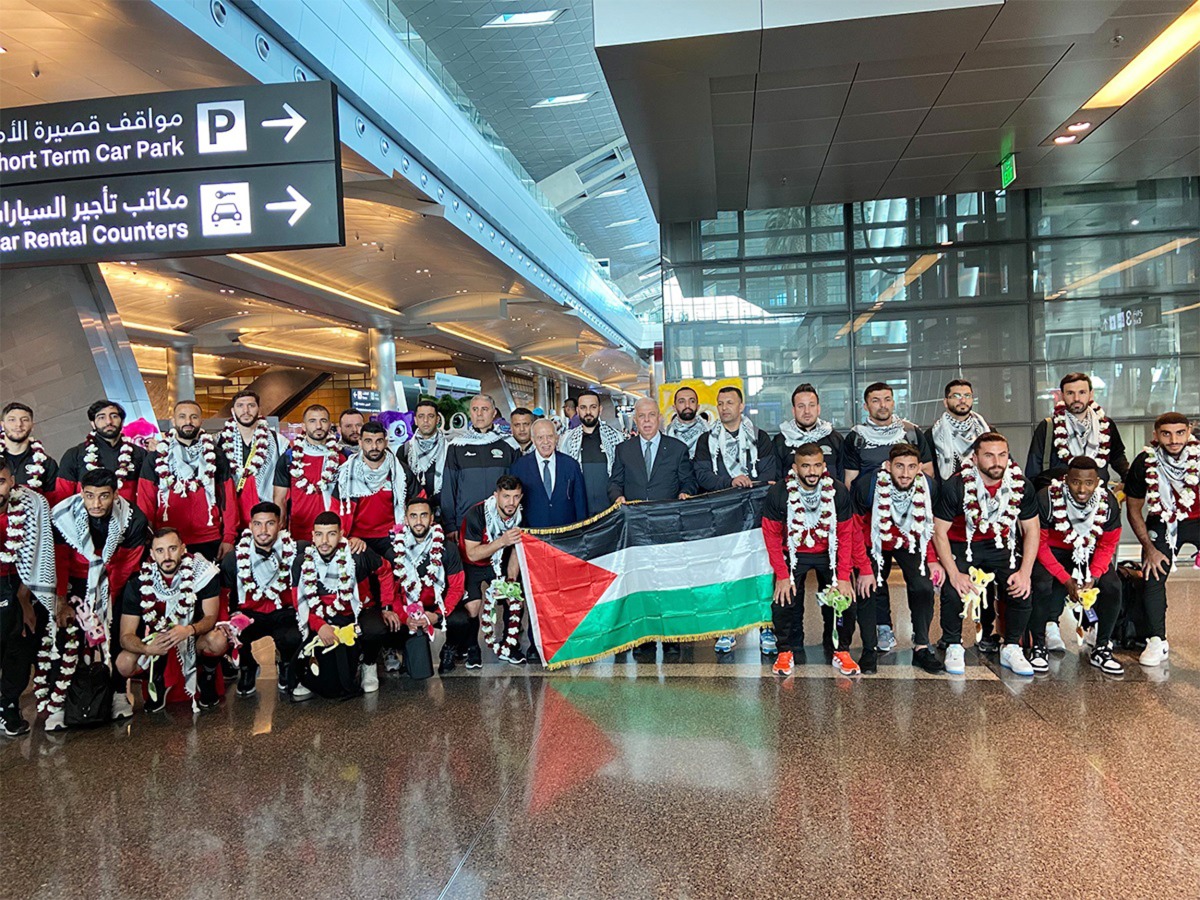 Palestine players and officials pose for a group photo after arriving in Doha. 