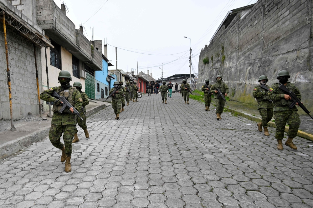 Army members patrol at the Lucha de los Pobres neighbourhood in southern Quito, on January 12, 2024. (Photo by Stringer / AFP)