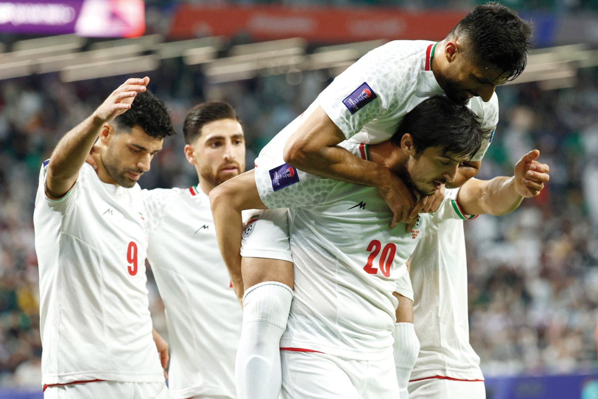 Sardar Azmoun celebrates with teammates after scoring Iran's fourth goal against Palestine. AFP