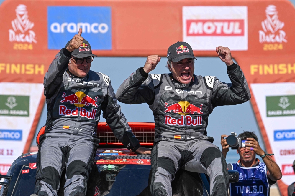 eam Audi Sport's Spanish driver Carlos Sainz (R) and his Spanish co-driver Lucas Cruzof (L) celebrate on their car after crossing the finish line of stage 12 of the Dakar rally 2024 from Yanbu to Yanbu, on January 19, 2024, at the end. Photo by PATRICK HERTZOG / AFP