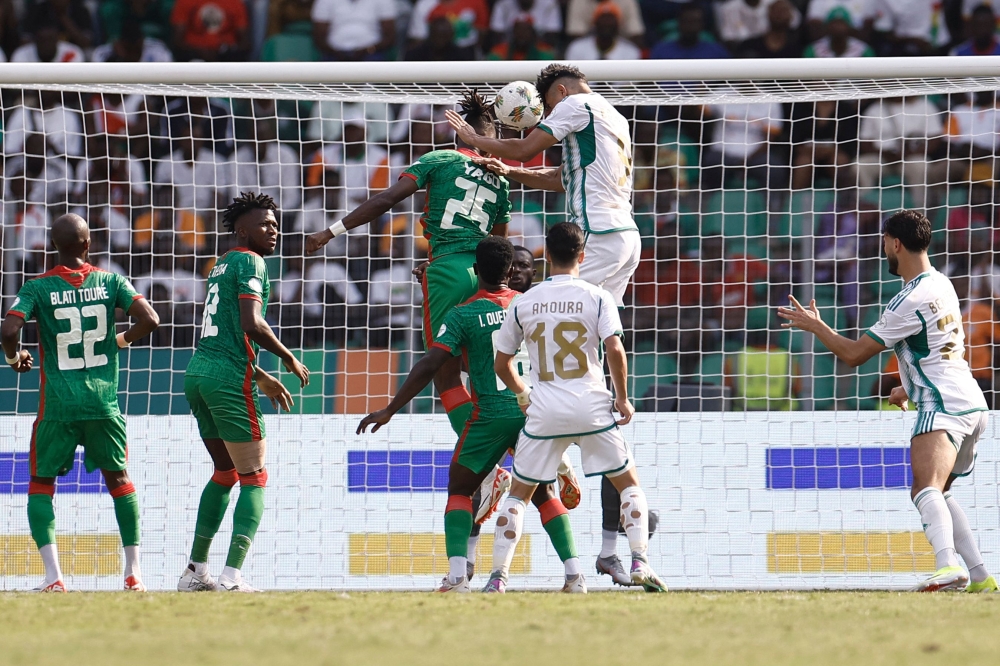 Algeria's forward #9 Baghdad Bounedjah (CR) heads the ball to score his team's second goal during the Africa Cup of Nations (CAN) 2024 group D football match between Algeria and Burkina Faso at Stade de la Paix in Bouake on January 20, 2024. (Photo by KENZO TRIBOUILLARD / AFP)
