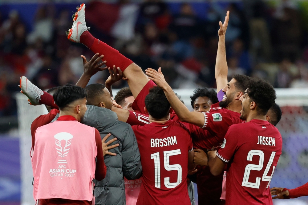 Qatar's players celebrate with their forward #10 Hassan Al-Haydos after he scored their first goal during the Qatar 2023 AFC Asian Cup Group A football match between Qatar and China at Khalifa International Stadium in Doha on January 22, 2024. (Photo by Karim Jaafar / AFP)