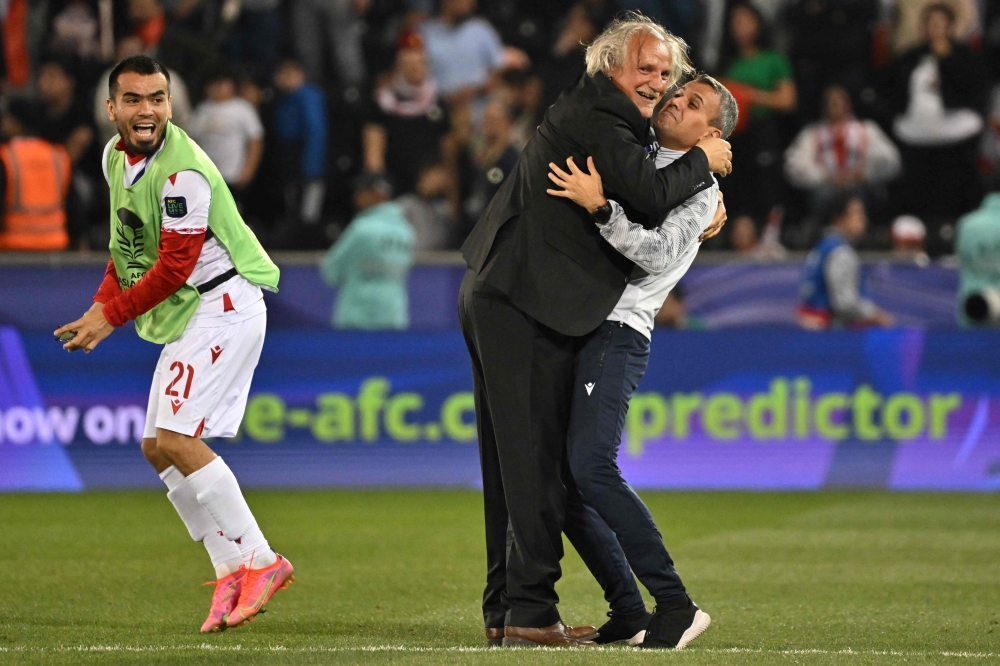 Tajikistan's Croatian coach Petar Segrt celebrates with his assistant after the Qatar 2023 AFC Asian Cup Group A football match between Tajikistan and Lebanon at the Jassim bin Hamad Stadium in Doha on January 22, 2024. (Photo by Hector Retamal / AFP)