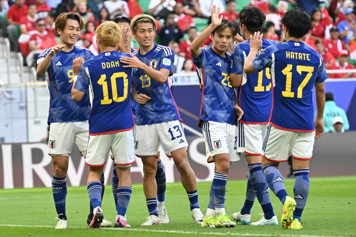 Japan's players celebrate after their second goal during the Qatar 2023 AFC Asian Cup Group D football match between Japan and Indonesia at al-Thumama Stadium in Doha on January 24, 2024. (Photo by HECTOR RETAMAL / AFP)
