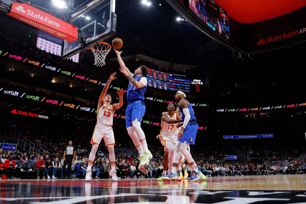 Luka Doncic #77 of the Dallas Mavericks goes up for a shot against Bogdan Bogdanovic #13 of the Atlanta Hawks during the first quarter at State Farm Arena on January 26, 2024 in Atlanta, Georgia. (Photo by Todd Kirkland / GETTY IMAGES NORTH AMERICA / Getty Images via AFP)
