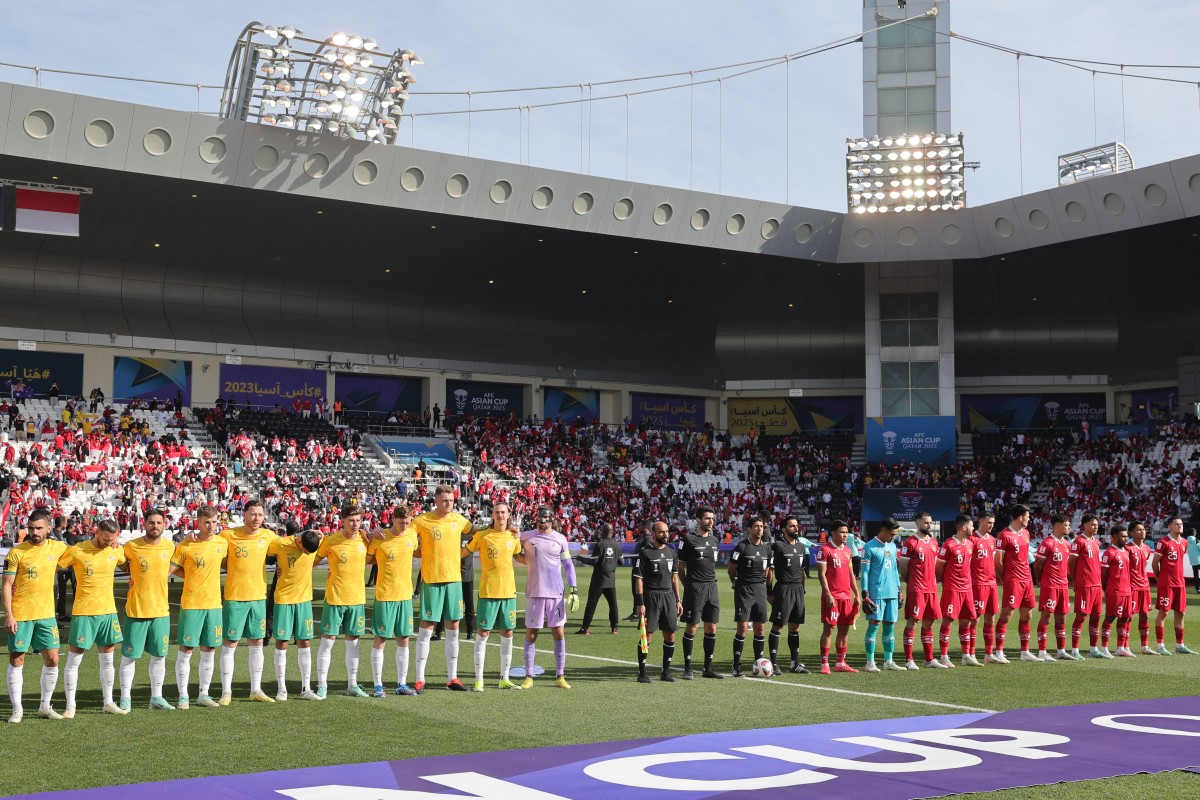 Indonesia's players (R) and Australia's players stand for their national anthems before the start of their match at Jassim bin Hamad Stadium in Doha on January 28, 2024. Photo by Giuseppe Cacace / AFP