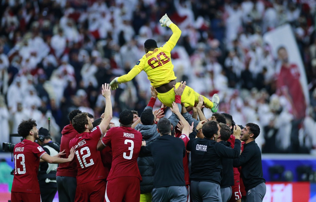 Qatar's players and officials toss goalkeeper Meshaal Barsham in the air after the victory at Al Bayt Stadium, yesterday.