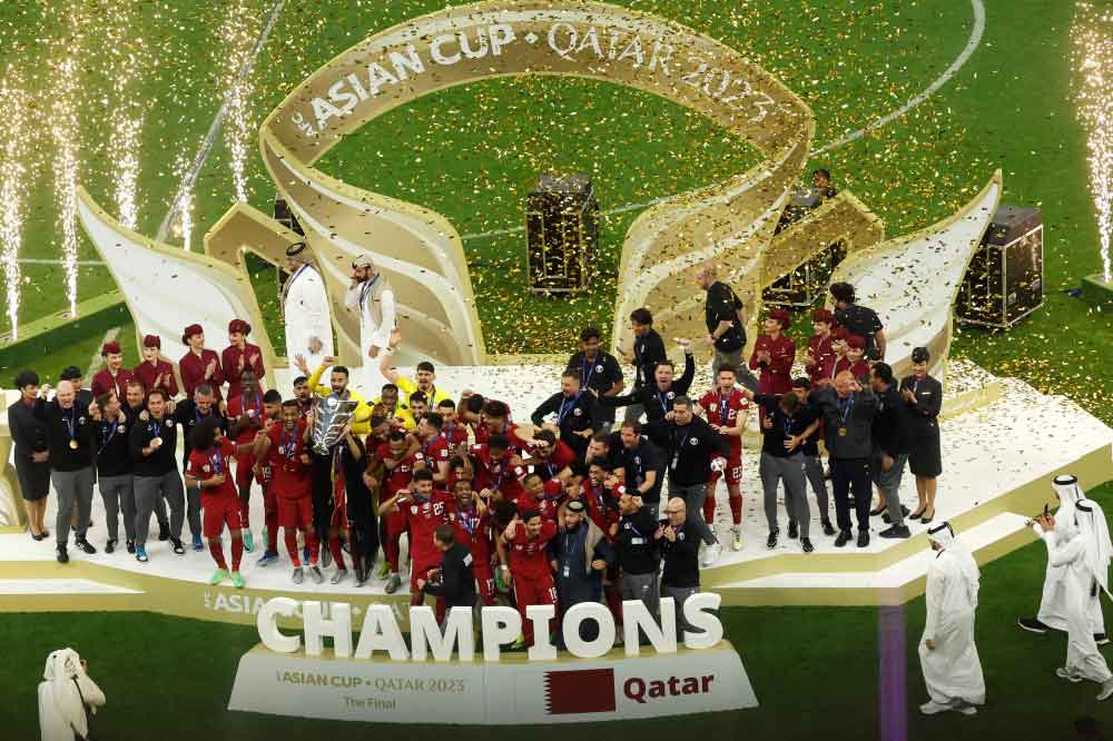 Qatar's players celebrate with the Qatar 2023 AFC Asian Cup trophy during the podium ceremony after the final football match between Jordan and Qatar at the Lusail Stadium in Lusail, north of Doha on February 10, 2024. (Photo by KARIM JAAFAR / AFP)
