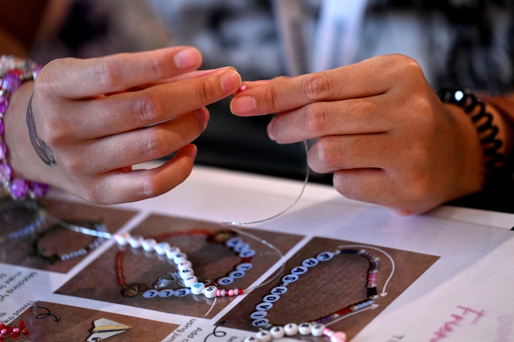 Delegates take part in a bracelet-making event during the Taylor Swift 