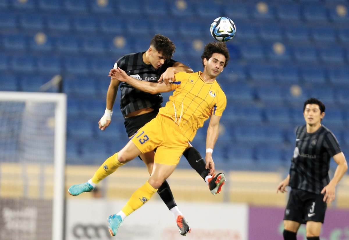 Al Gharafa's Ahmed Alaaeldin (front) vies for the ball possession with an Al Rayyan player. 