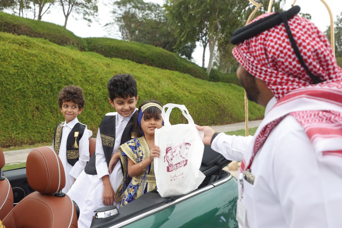 An official distributing Garangao gifts to children on Shakespeare Street in Katara yesterday.