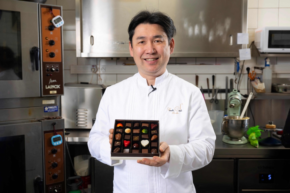 Japanese chocolatier Yasushi Sasaki holds a box of chocolates as he poses for a photograph in his workshop in the Brussels commune of Woluwe-Saint-Pierre on March 14, 2024. (Photo by John Thys / AFP)