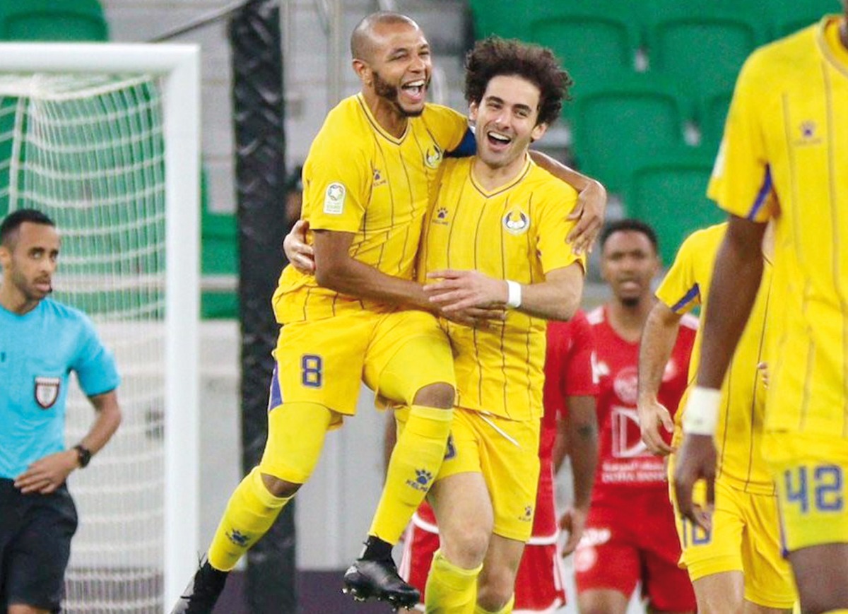 Al Gharafa's Ahmed Alaaeldin (centre) celebrates with captain Yacine Brahimi after scoring a goal against Al Arabi, yesterday.