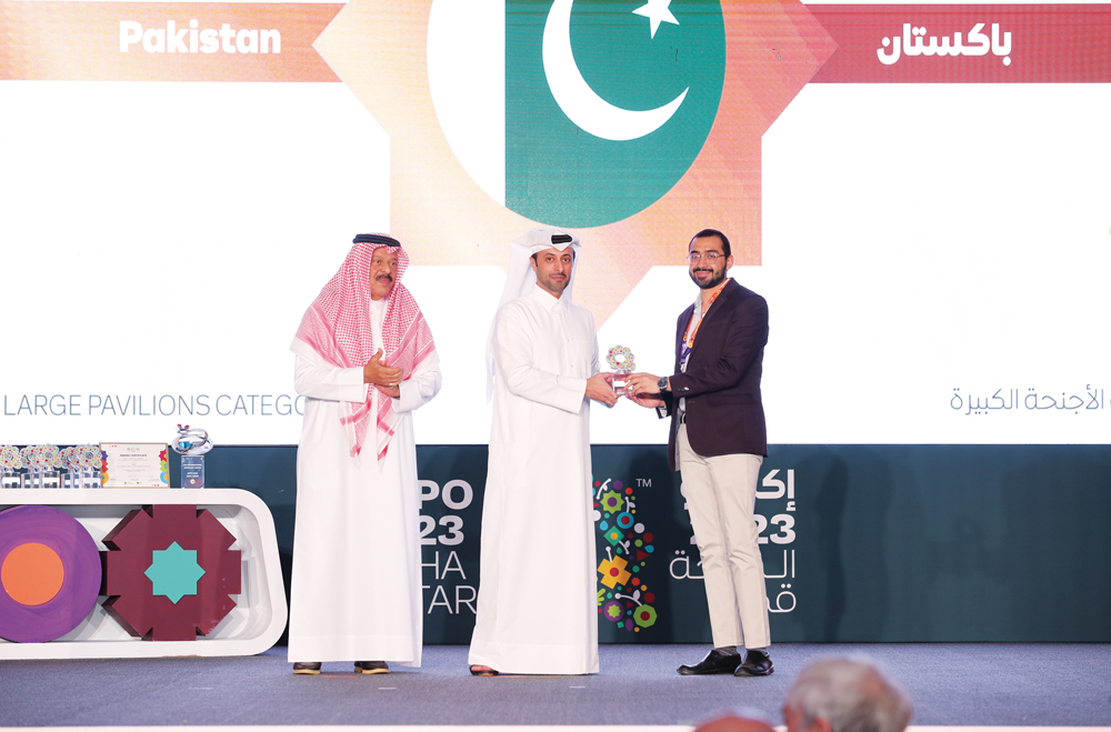 Minister of Municipality H E Abdullah bin Hamad bin Abdullah Al Attiyah (centre) honouring a  representative of Pakistan Pavilion at Expo 2023 Doha. 