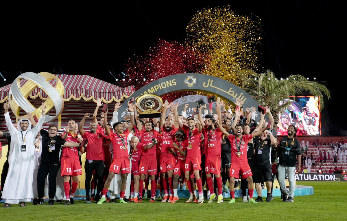 Shabab Al Ahli's players and officials celebrate their Qatar-UAE Super Shield triumph in Dubai yesterday.


