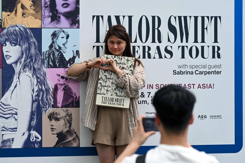 Fans of US singer Taylor Swift, also known as Swifties, take photos as they arrive for the pop star's Eras Tour concert at the National Stadium in Singapore on March 7, 2024. (Photo by Roslan RAHMAN / AFP)

