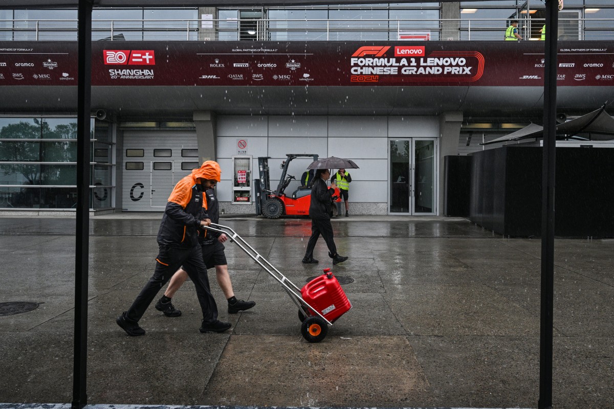 Formula One team members walk next to the paddock at the Shanghai International circuit ahead of the Formula One Chinese Grand Prix in Shanghai on April 17, 2024. (Photo by HECTOR RETAMAL / AFP)
