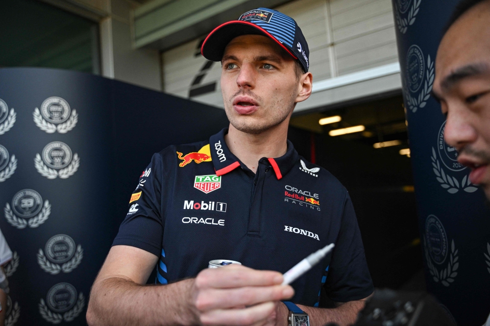 Red Bull Racing's Dutch driver Max Verstappen signs an autograph at the Shanghai International circuit ahead of the Formula One Chinese Grand Prix in Shanghai on April 18, 2024. (Photo by Pedro Pardo / AFP)