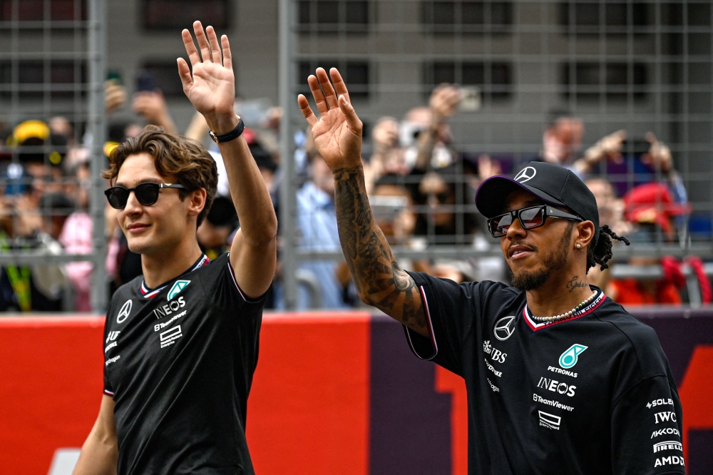 Mercedes' British driver George Russell (L) and Mercedes' British driver Lewis Hamilton (R) arrive ahead of the Formula One Chinese Grand Prix race at the Shanghai International Circuit in Shanghai on April 21, 2024. (Photo by PEDRO PARDO / AFP)