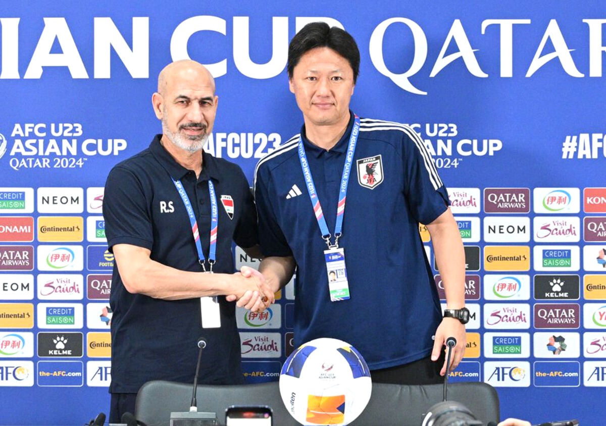 Iraq coach Radhi Shenaishil (left) and Japan coach Go Oiwa shake hands at a press conference yesterday. AFC 