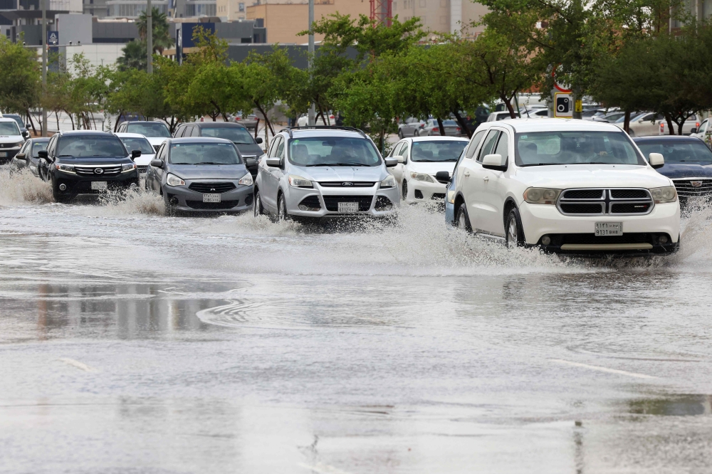 Cars drive through standing water in the Saudi capital Riyadh following strong winds and heavy rain overnight that flooded roads in different regions of the desert kingdom on May 1, 2024. (Photo by Fayez Nureldine / AFP)