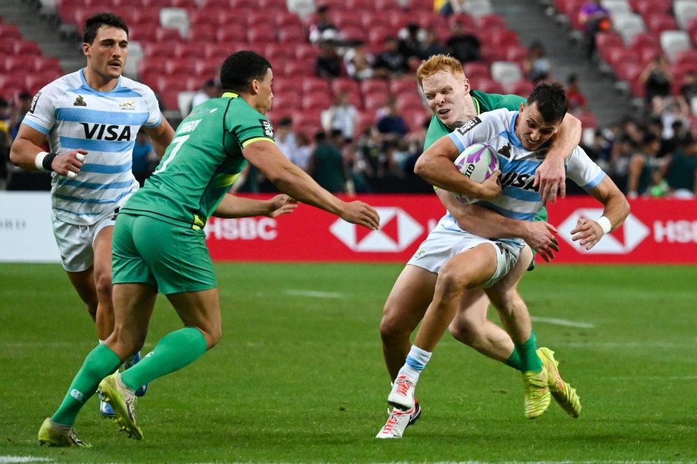 Argentina's Tobias Wade is tackled by Ireland痴 Gavin Mullin during the men's Cup quarter-final match between Argentina and Ireland at the HSBC Rugby Sevens tournament at the National Stadium in Singapore on May 4, 2024. (Photo by Roslan RAHMAN / AFP)