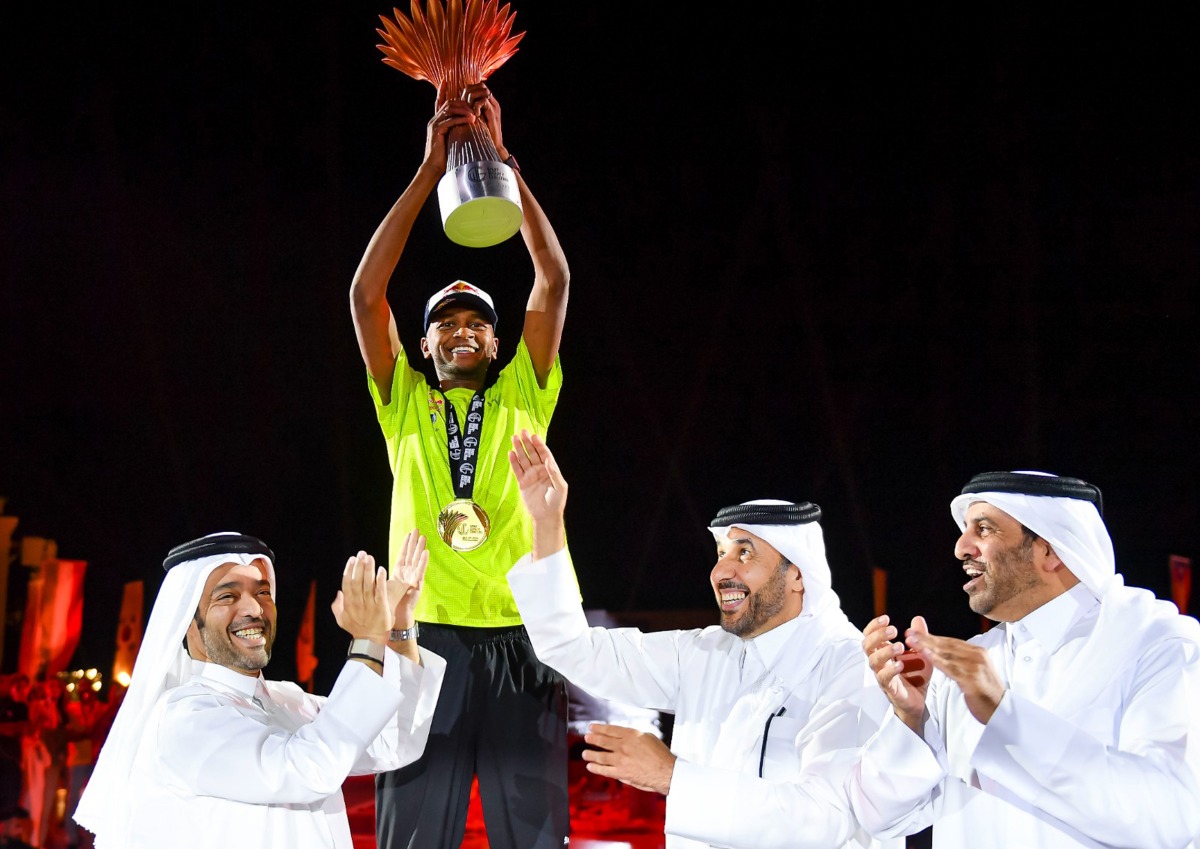 Mutaz Marshim celebrates after receiving the trophy from Second Vice President of Qatar Olympic Committee Dr Thani bin Abdulrahman Al Kuwari.