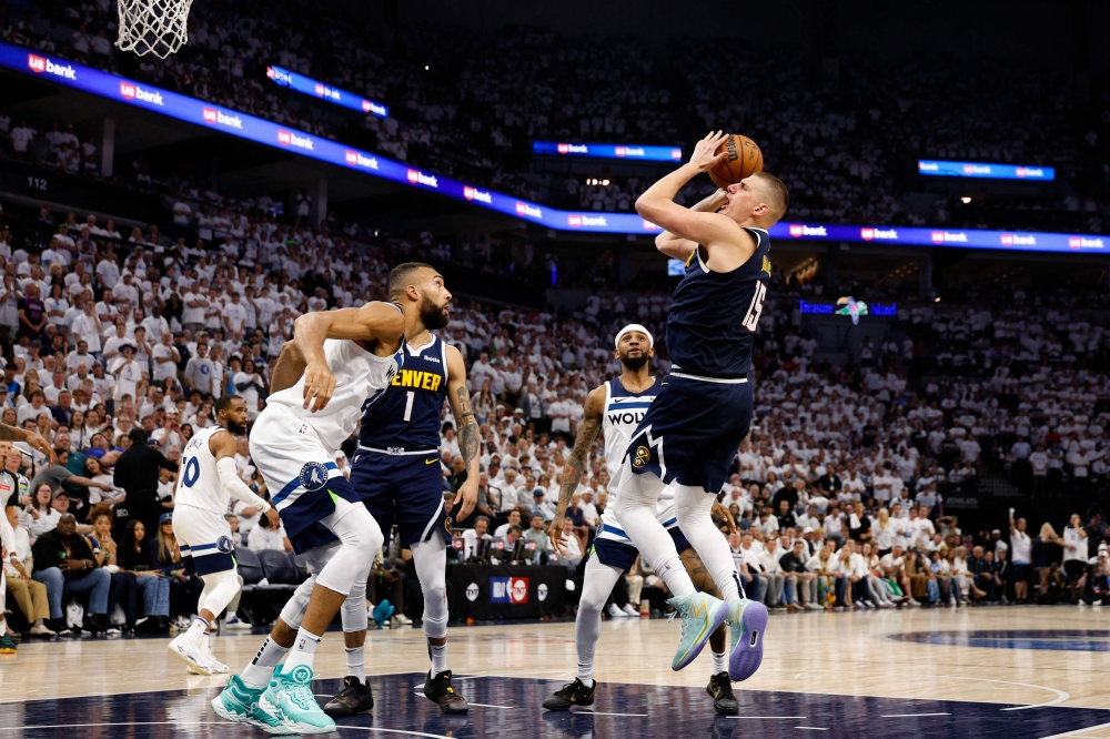 Nikola Jokic #15 of the Denver Nuggets takes a shot over Rudy Gobert #27 of the Minnesota Timberwolves during the fourth quarter in Game Four of the Western Conference Second Round Playoffs at Target Center on May 12, 2024 in Minneapolis, Minnesota. (Photo by David Berding / GETTY IMAGES NORTH AMERICA / Getty Images via AFP)
