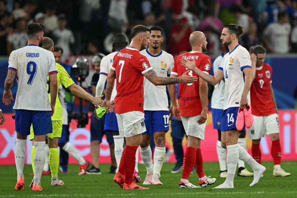 :France's midfielder #14 Adrien Rabiot (R) shakes hand with Austria's forward #07 Marko Arnautovic at the end of the UEFA Euro 2024 Group D football match between Austria and France at the Duesseldorf Arena in Duesseldorf on June 17, 2024. (Photo by OZAN KOSE / AFP)
