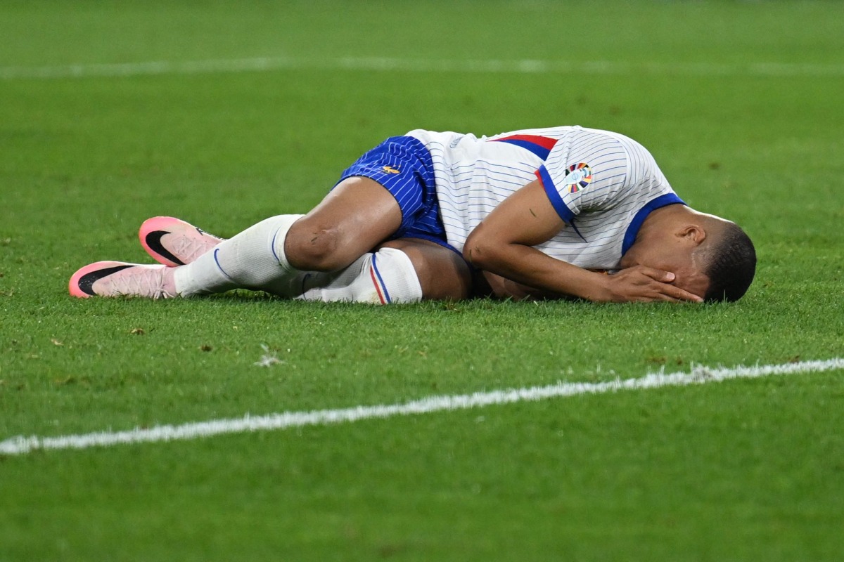 France's forward Kylian Mbappe lies on the football pitch after being injured during the UEFA Euro 2024 Group D football match between Austria and France at the Duesseldorf Arena in Duesseldorf on June 17, 2024. (Photo by OZAN KOSE / AFP)