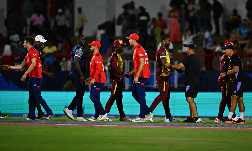 Players meet on the field after England won the ICC men's Twenty20 World Cup 2024 Super Eight cricket match against West Indies on June 19, 2024. (Photo by Chandan Khanna / AFP)