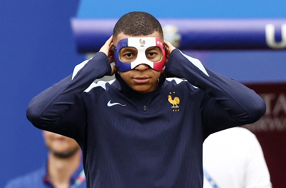 France's forward #10 Kylian Mbappe wears a face mask as he takes part in a MD-1 training session at the Leipzig Stadium in Leipzig on June 20, 2024, on the eve of their UEFA Euro 2024 Group D football match against Netherlands. (Photo by Franck Fife / AFP)