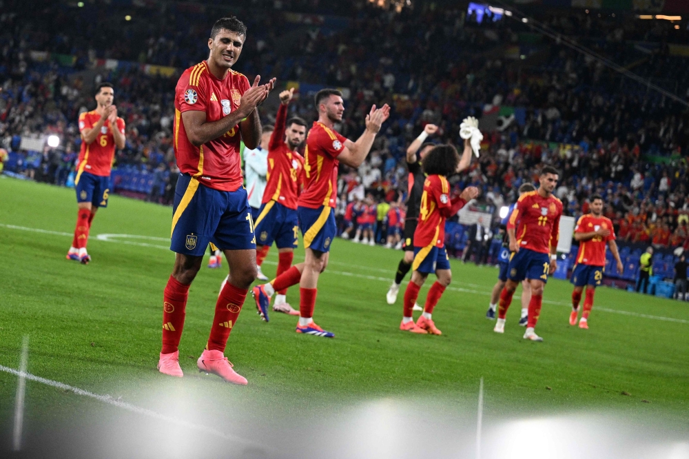 Spain's midfielder #16 Rodri (left) and teammates applaud fans on the pitch after the UEFA Euro 2024 Group B football match between Spain and Italy at the Arena AufSchalke in Gelsenkirchen on June 20, 2024. Spain won the game 1-0. (Photo by Patricia De Melo Moreira / AFP)