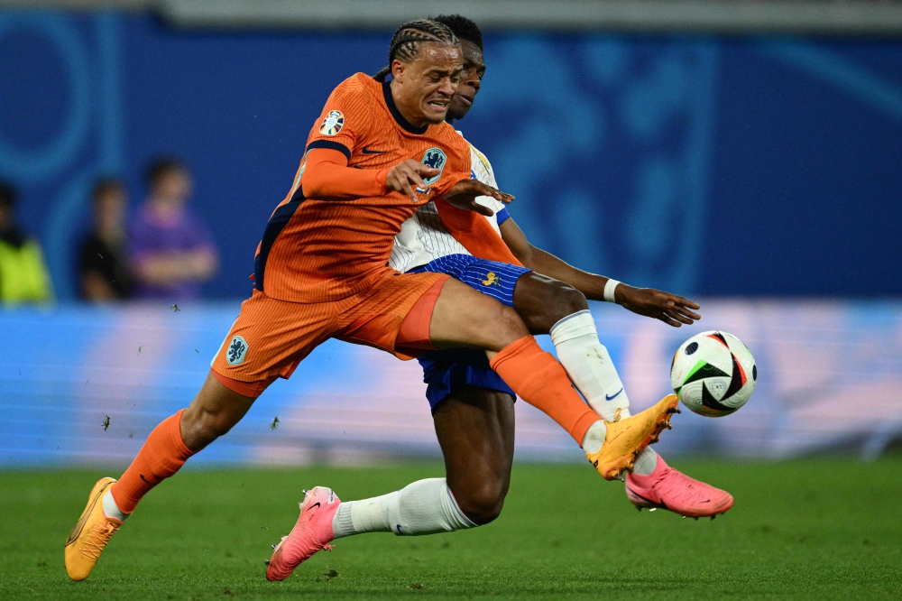 France's midfielder #08 Aurelien Tchouameni (Rear) and Netherlands' forward #07 Xavi Simons fight for the ball during the UEFA Euro 2024 Group D football match between the Netherlands and France at the Leipzig Stadium in Leipzig on June 21, 2024. (Photo by Christophe Simon / AFP)