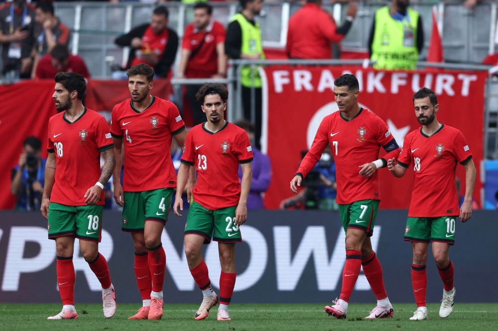 (From L) Portugal's midfielder #18 Ruben Neves, Portugal's defender #04 Ruben Dias, Portugal's midfielder #23 Vitinha, Portugal's forward #07 Cristiano Ronaldo and Portugal's midfielder #10 Bernardo Silva celebrate their team's third goal during the UEFA Euro 2024 Group F football match between Turkey and Portugal at the BVB Stadion in Dortmund on June 22, 2024. (Photo by FRANCK FIFE / AFP)
