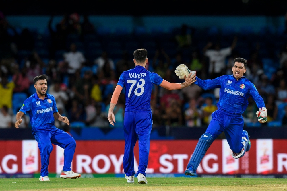 Afghanistan's Nangyal Kharoti (L), Naveen-ul-Haq (C) and Gulbadin Naib (R) celebrates after the dismissal of Australia's Ashton Agar on June 22, 2024. (Photo by Randy Brooks / AFP)