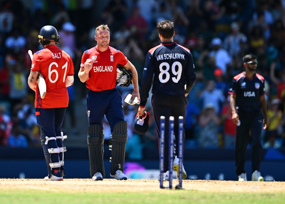 England's captain and wicketkeeper Jos Buttler (C) goes to shake hands with USA's Shadley Van Schalkwyk after England won the ICC men's Twenty20 World Cup 2024 Super Eight cricket match between USA and England at Kensington Oval in Bridgetown, Barbados on June 23, 2024. (Photo by Chandan Khanna / AFP)
