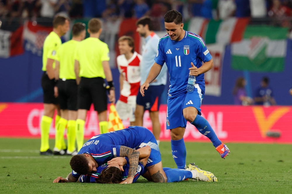 Italy's forward #20 Mattia Zaccagni (down) celebrates with teammates at the end of the UEFA Euro 2024 Group B football match between Croatia and Italy at the Leipzig Stadium in Leipzig on June 24, 2024. (Photo by Odd ANDERSEN / AFP)
