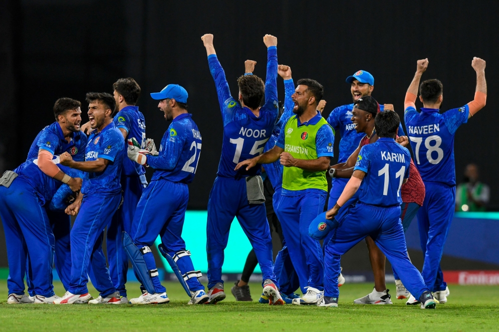 Afghanistan's players celebrate winning their ICC men's Twenty20 World Cup 2024 Super Eight cricket match against Bangladesh at Arnos Vale Stadium in Arnos Vale, Saint Vincent and the Grenadines on June 24, 2024. (Photo by Randy Brooks / AFP)
