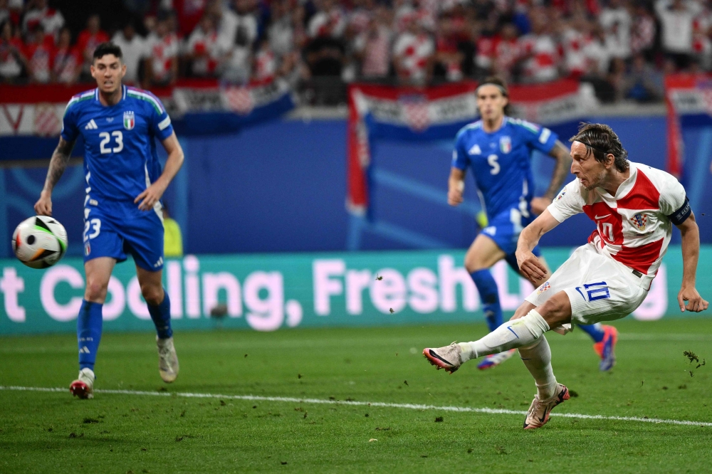 Croatia's midfielder #10 Luka Modric (R) scores his team's first goal during the UEFA Euro 2024 Group B football match between the Croatia and Italy at the Leipzig Stadium in Leipzig on June 24, 2024. (Photo by Christophe Simon / AFP)