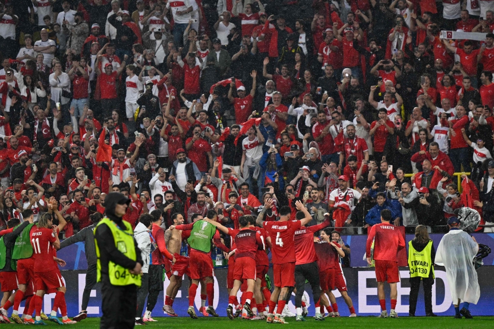 Turkiye's players celebrate with their supporters after the UEFA Euro 2024 Group F football match between Turkey and Georgia at the BVB Stadion in Dortmund on June 18, 2024. (Photo by INA FASSBENDER / AFP)