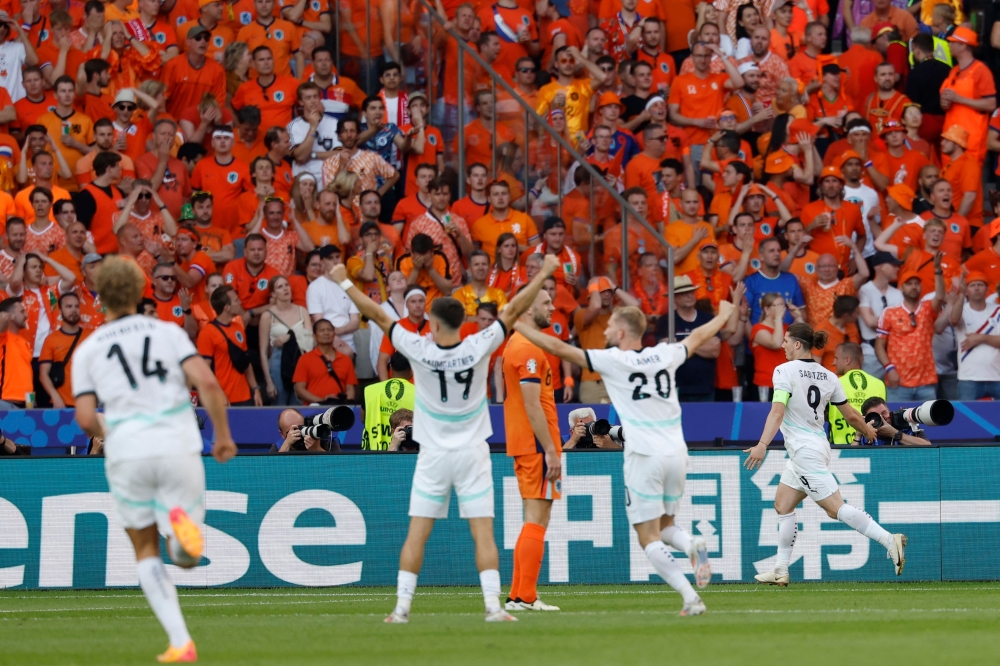 Austria's midfielder #09 Marcel Sabitzer (right) celebrates scoring his team's third goal with his teammates during the UEFA Euro 2024 Group D football match between the Netherlands and Austria at the Olympiastadion in Berlin on June 25, 2024. (Photo by Odd Andersen / AFP)