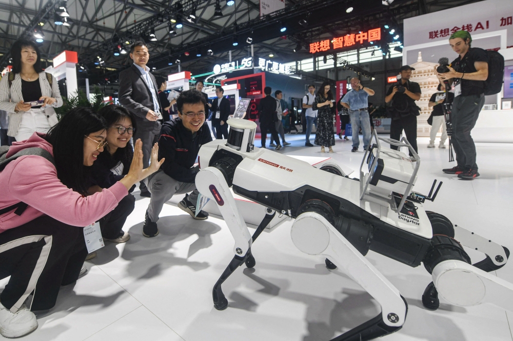 Visitors interact with a Lenovo robot at the Mobile World Congress (MWC) in Shanghai on June 26, 2024. (Photo by AFP)
 