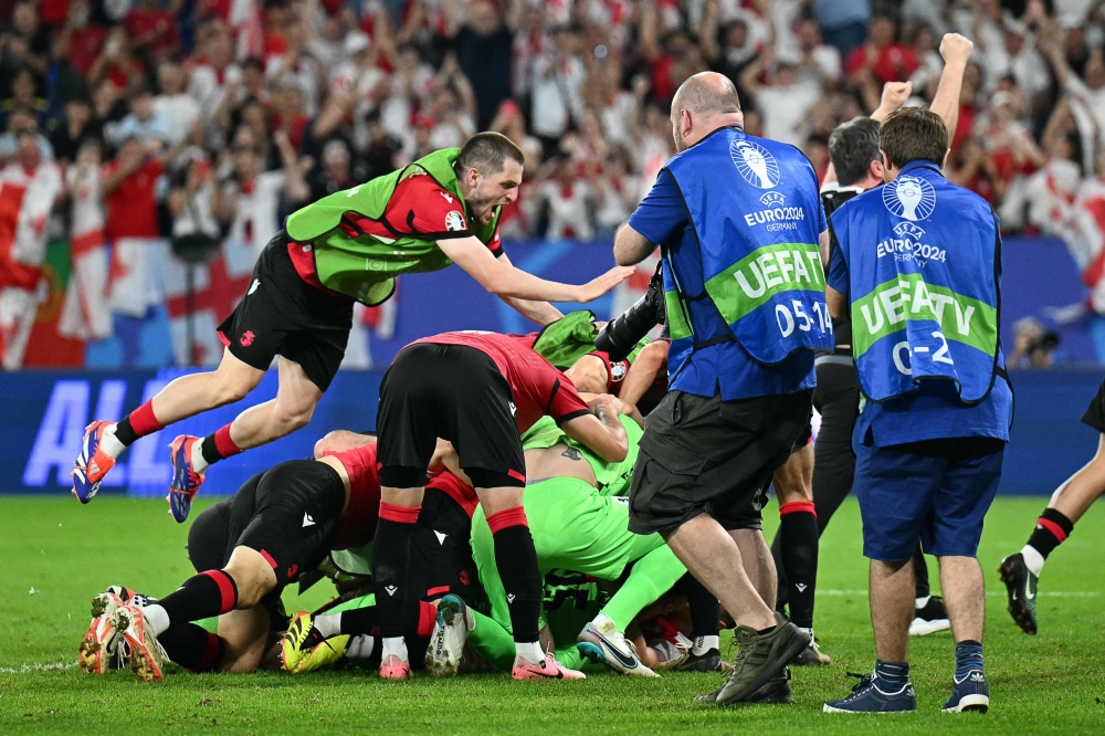 Georgia's players celebrate after winning the UEFA Euro 2024 Group F football match between Georgia and Portugal at the Arena AufSchalke in Gelsenkirchen on June 26, 2024. (Photo by Patricia De Melo Moreira / AFP)